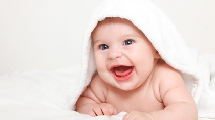 Laughing baby with towel