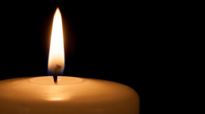 White candle on black background with copy space for text