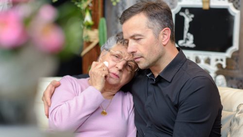 Twee personen die elkaar in de arm hebben en verdriet hebben