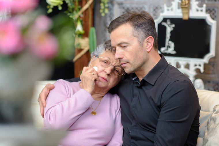 Twee personen die elkaar in de arm hebben en verdriet hebben